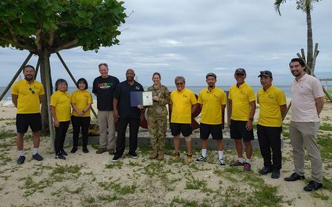 Photo Of Lt Col Hoffman and Mr. Tanaka pose with Torii Outdoor Rec staff  members on the beach.