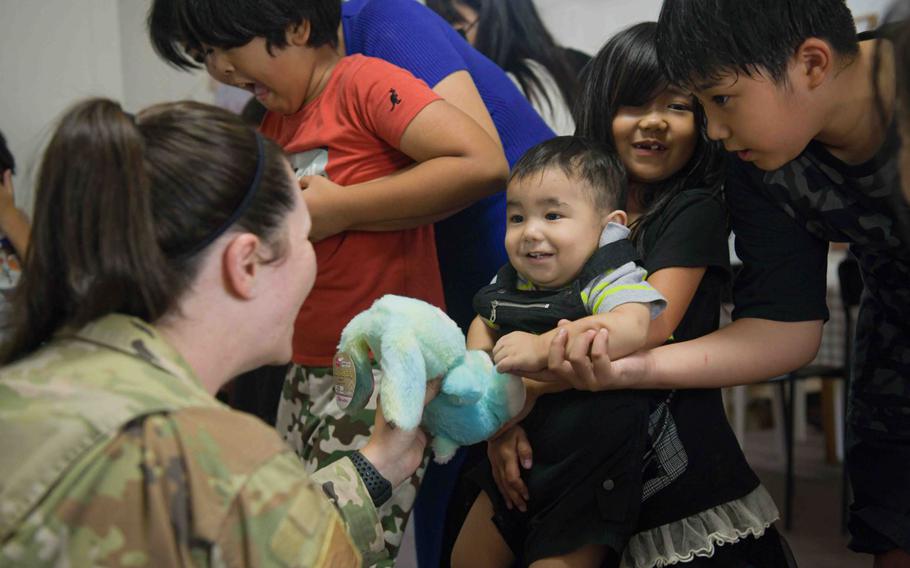 U.S. Air Force Tech. Sgt. Brittany Sampson, 353rd Special Operations Wing, occupational safety manager plays with a toddler during a Christmas in July event at a child support facility outside Kadena Air Base, Japan, July 23, 2024. Christmas in July is an annual volunteer donation event initiated by the 18th Wing Safety, and has been going on for the past four years.