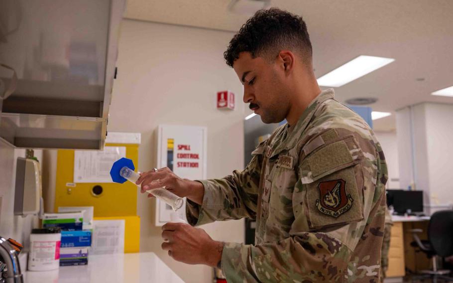 U.S. Air Force Staff Sgt. Malachi Hailstalk, 18th Medical Support Squadron pharmacy technician, pours medication into a prescription bottle, on Kadena Air Base.