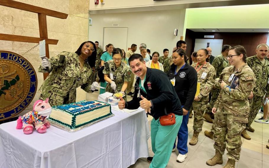 Sailors from USNMRTC Okinawa enjoys cake the morning of the MHS GENESIS launch.