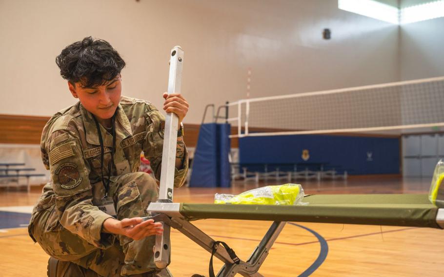 Airman 1st Class Nadalyia Flores Ahmad, 718th Force Support Squadron assignments technician, assembles a cot during a routine readiness exercise at Kadena Air Base, Japan, May 7, 2025. The setup was part of a simulated “safe haven” operation involving multiple FSS members, aimed at assessing the squadron’s capability to quickly establish emergency shelter accommodations. 