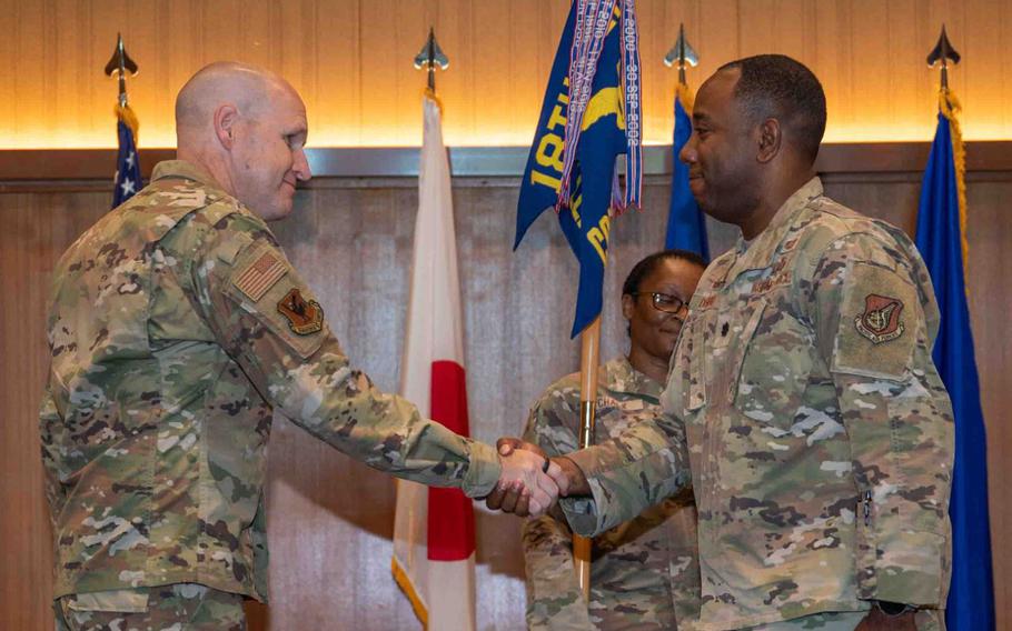 U.S. Air Force Brig. Gen. Nicholas B. Evans, 18th Wing Commander, shakes hands with U.S. Air Force Lt. Col. Allen F. Dismuke Jr., 18th Comptroller Squadron incoming commander.