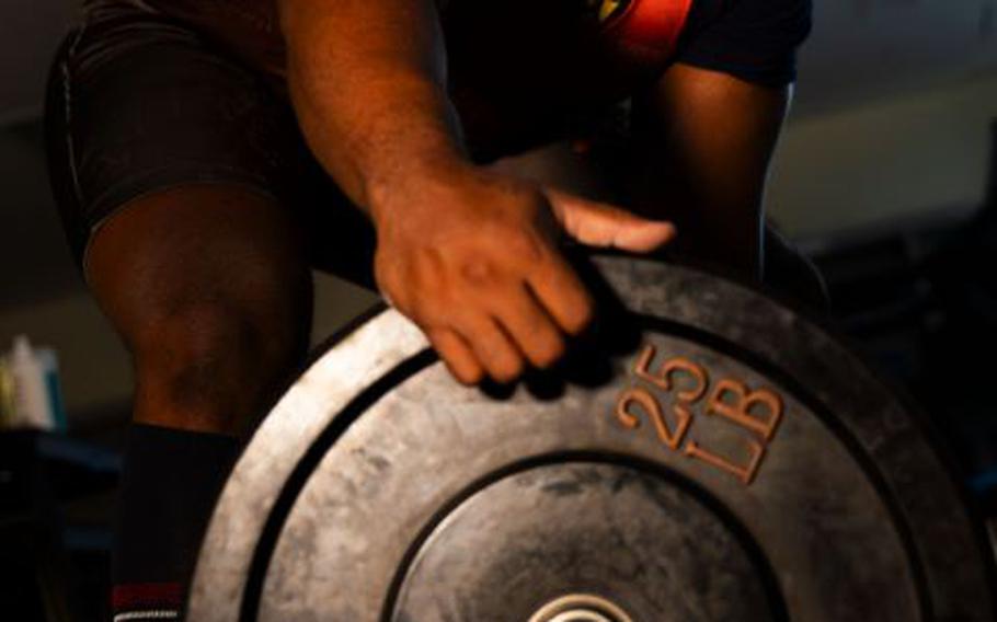 Ian Bell, 18th Logistics Readiness Squadron True North social worker and powerlifter, loads plates onto a barbell before lifting weights Kadena Air Base, Japan, Feb. 16, 2024. Ian is the current holder of the International Powerlifting Federation Equipped Deadlift World Record for the 105-kilogram weight class (856.5 pounds/388.5 kilograms). 