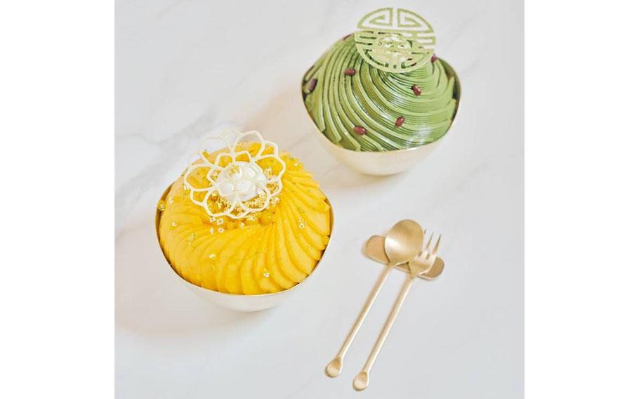 Two bingsu, a spoon, and a fork are on the table.