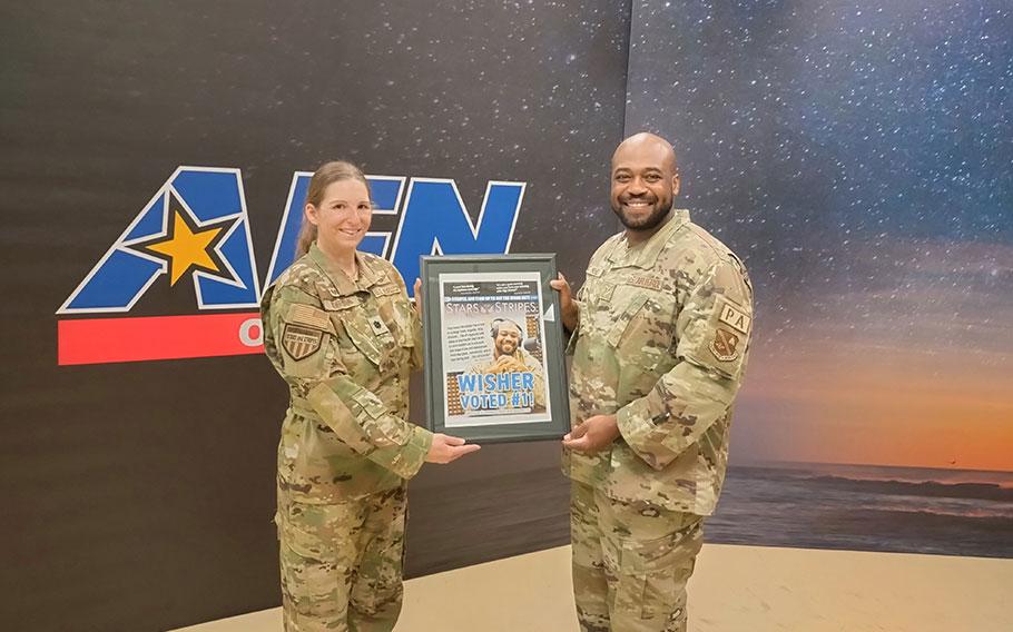 Stars and Stripes Pacific Commander Lt. Col. Marci Hoffman presenting Best AFN Radio Personality award to SSgt Matthew Wisher.