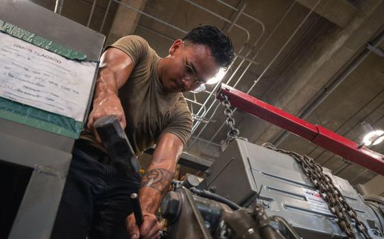 U.S. Air Force Senior Airman Seth Aguon positions an engine on a line trailer.