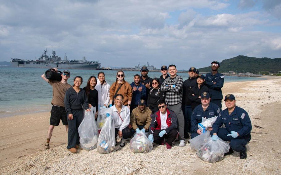 Sailors assigned to USS America pose for a photo on the beach.