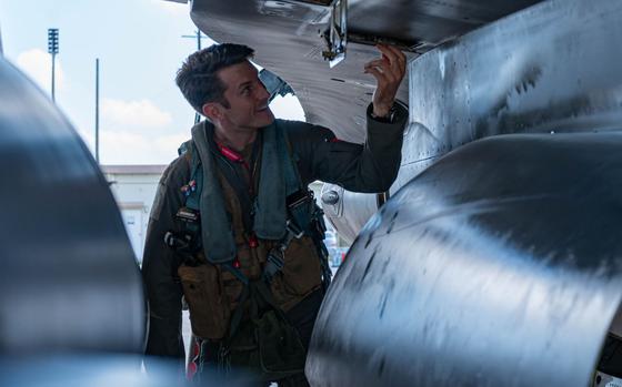 Photo Of U.S. Air Force Maj. James Gregory smilingly performs pre-flight checks on a U.S. Air Force F-16C Fighting Falcon.