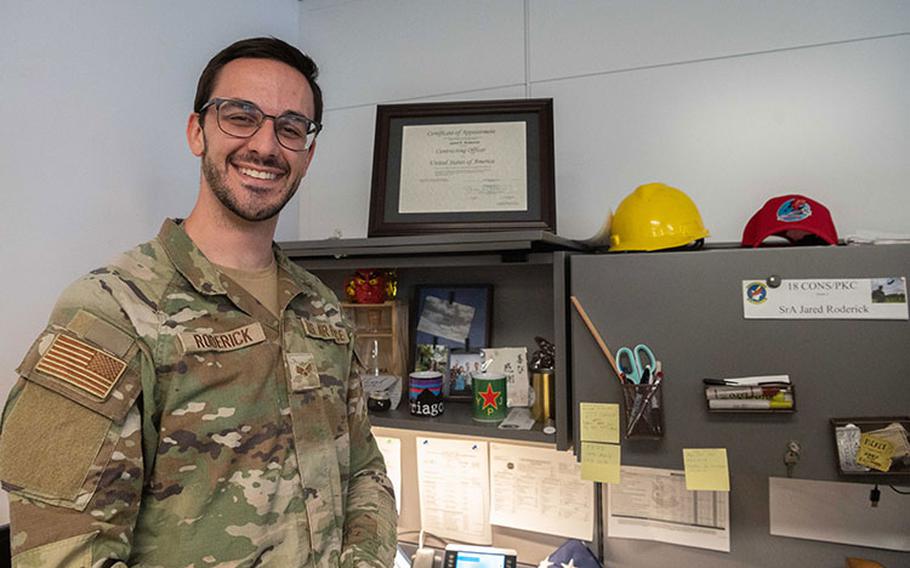 Senior Airman Jared Roderick, 18th Contracting Squadron contract specialist, stands by his work station for a photo at Kadena Air Base, Japan, March 27, 2023. Acting as the middleman between the government and vendors, contracting officers plan and execute contracts to optimize taxpayers dollars. (U.S. Air Force photo by Senior Airman Yosselin Campos)