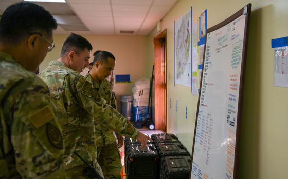 Photo Of U.S. Air Force Tech. Sgt. Kevin Fitch, center, 199th Fighter Generation Squadron flight line expediter, explains flightline information to Tech. Sgt. Robert Shikina, left, 199th FGS network systems operations noncommissioned officer in charge, and Airman 1st Class Nel Venzon, 199th FGS intel analyst, during a Crew Chief for a Day event at Kadena Air Base, Japan, Aug. 20, 2024.