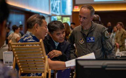 Photo Of U.S. Air Force Col. Joshua Lundeby, 18th Wing deputy commander, reviews vendor information at Kadena Air Base.