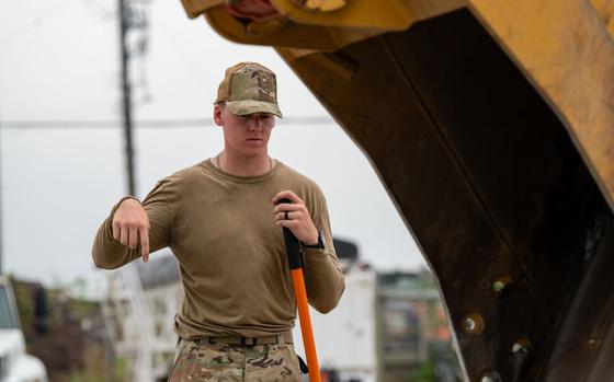 Photo Of U.S. Air Force Senior Airman Kody Kross, 374th Civil Engineer Squadron (CES) heavy equipment operator, directs an excavator during a Rapid Airfield Damage Recovery exercise at Yokota Air Base, Japan, Aug. 22, 2024.