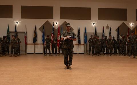 Photo Of Chief Warrant Officer 5 Rene Garcia, director for Installation Personnel Administration Center, Marine Corps Installations Pacific, receives the U.S. flag during his retirement ceremony on Camp Foster.