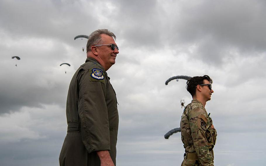 U.S. Air Force Lt. Gen. Ricky Rupp, left, U.S. Forces Japan and Fifth Air Force commander, and a service member with the 31st Rescue Squadron, watch 31st RQS pararescuemen land during a parachute drop training at Kadena Air Base, Japan, Jan. 19. 2024. 5th Air Force leaders observed the training by the 31st Rescue Squadron and 320th Special Tactics Squadron that occurred at Kadena while the conference was underway. (U.S. Air Force photo by Airman 1st Class Jonathan R. Sifuentes)