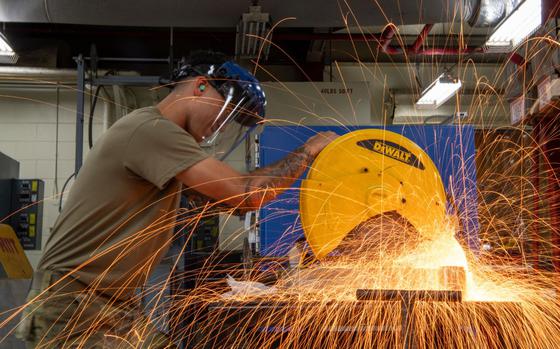 Photo Of U.S. Air Force Airman 1st Class Nicolas Flores, 18th Equipment Maintenance Squadron aircraft metals technology journeyman, cuts into a piece of metal with a sliding miter saw at Kadena Air Base, Japan, Aug. 29, 2024.