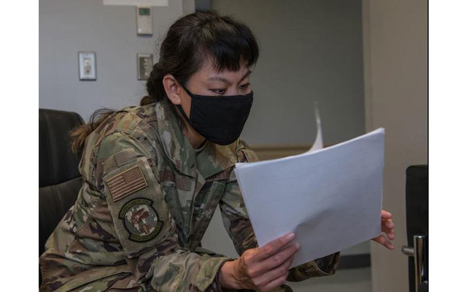 U.S. Air Force Maj. Joanna Ho, 18th Operational Medical Readiness Squadron director of psychological health, flips through papers on training for the Guardian Wingman program. Guardian Wingman could be a resource used across the Pacific Air Forces in the future, based on the efficacy data collected at Kadena AB. (U.S. Air Force photo by Airman 1st Class Anna Nolte)