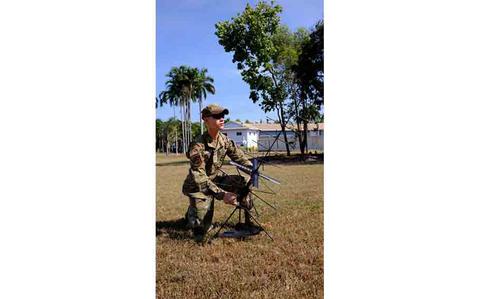 Photo Of U.S. Air Force Senior Airman Christopher Koon, 18th Communications Squadron expeditionary communications technician, sets up radio communications during exercise RECCE-Edge 25 at Royal Australian Air Force Base Darwin, Australia.