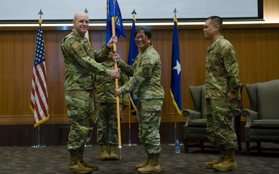 U.S. Air Force Col. Laura Ramos, center, outgoing 18th Mission Support Group commander, relinquishes the guidon to Brig. Gen. Nicholas Evans, left, 18th Wing commander, during the 18th MSG change of command ceremony at Kadena Air Base, Japan, July, 18, 2024.