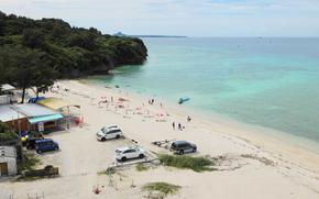 Some cars are parked on the beach.
