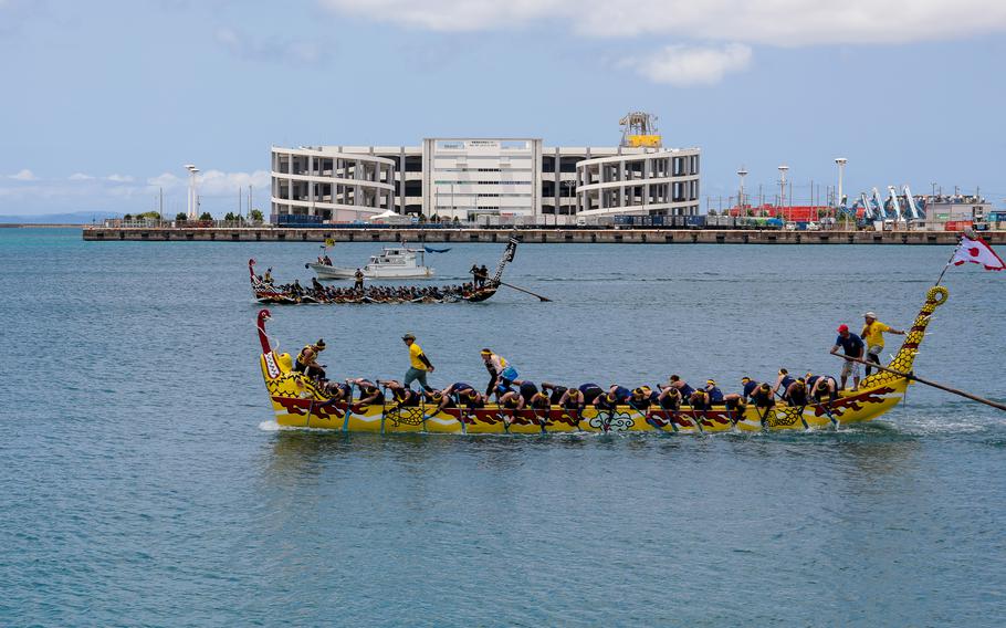 The Army Ladies Dragon Boat Team wins by a razor-thin margin against the Navy Ladies Dragon Boat Team at the Dragon Boat race in Nahashin Port, Okinawa.